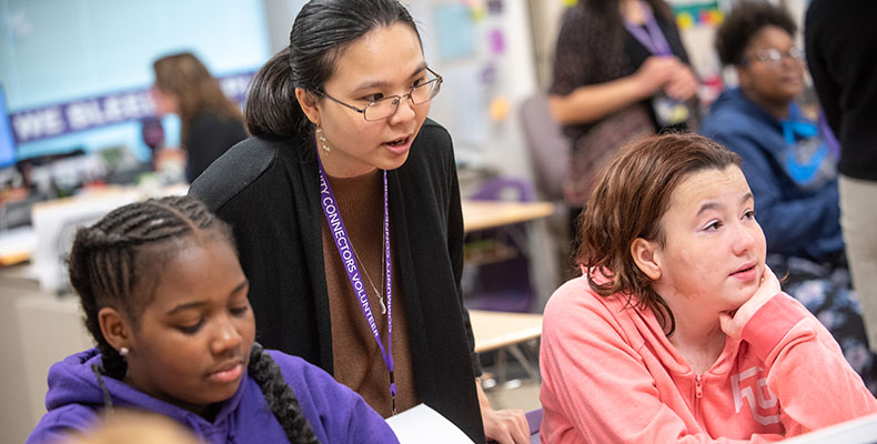 A Univerity of Akron student teacher working with children at a local primary school